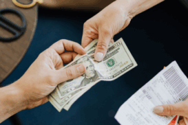 Pessoa entregando dólares em espécie enquanto recebe um recibo, simbolizando o fluxo de caixa em operações internacionais.