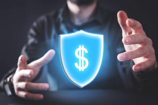 Pessoa com as mãos próximas a um escudo digital com símbolo de cifrão, representando a proteção financeira em estratégias de hedge parcial e hedge total.