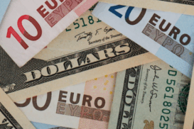 Notas de euro e dólar sobrepostas, ilustrando o conceito de conta em dólar ou euro para empresas brasileiras que atuam no comércio internacional.